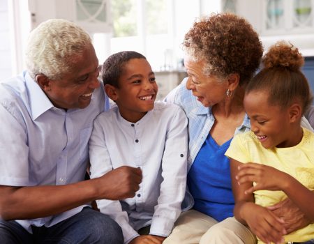 Grandparents and their young grandchildren relaxing at home