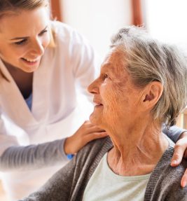 Health visitor and a senior woman during home visit. A nurse talking to an elderly woman.